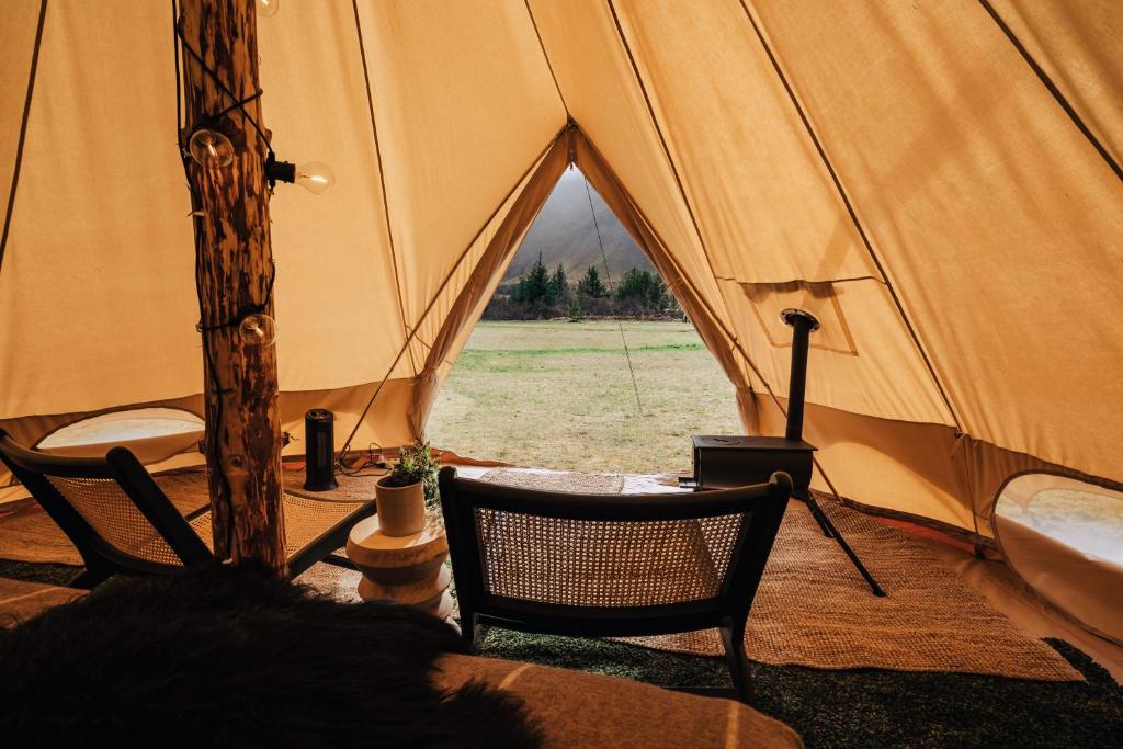 塞爾福斯的住宿－Golden Circle Tents - Glamping Experience，帐篷前配有2把椅子和1张桌子