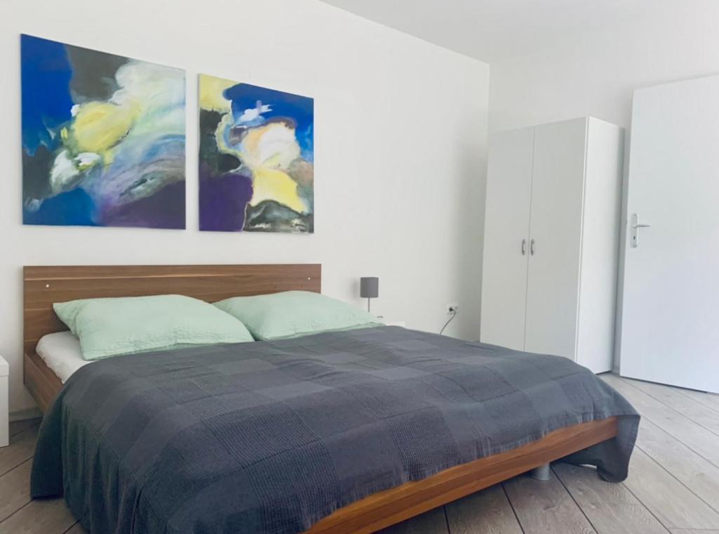 a bedroom with a bed with three paintings on the wall at Ferienwohnung in Bad Segeberg in Bad Segeberg