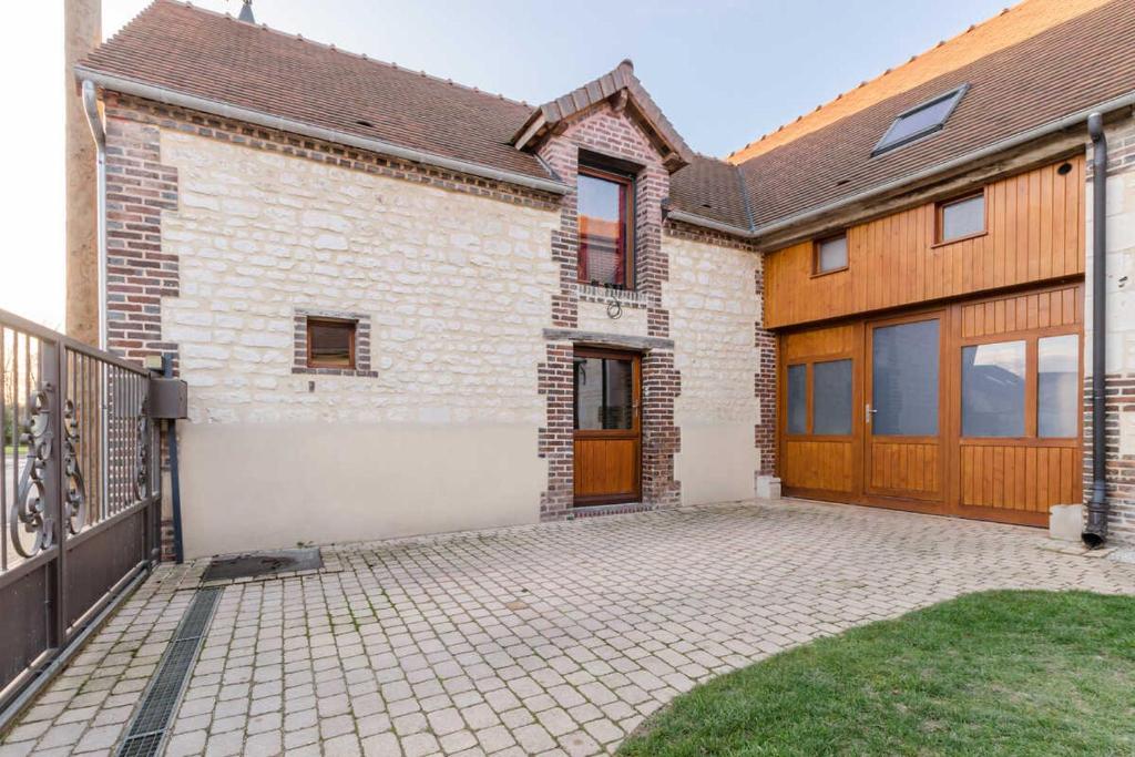 a brick house with a garage and a driveway at La maisonnette in Estissac