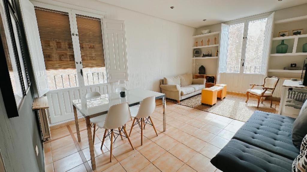 sala de estar con mesa, sillas y sofá en Portrait Home, en Cuenca