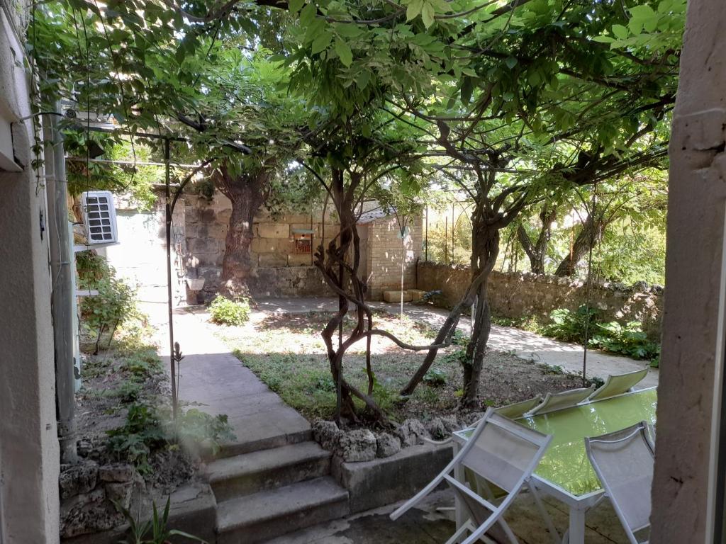 un jardín con 2 sillas y un árbol en La Galinette, en Arpaillargues-et-Aureillac