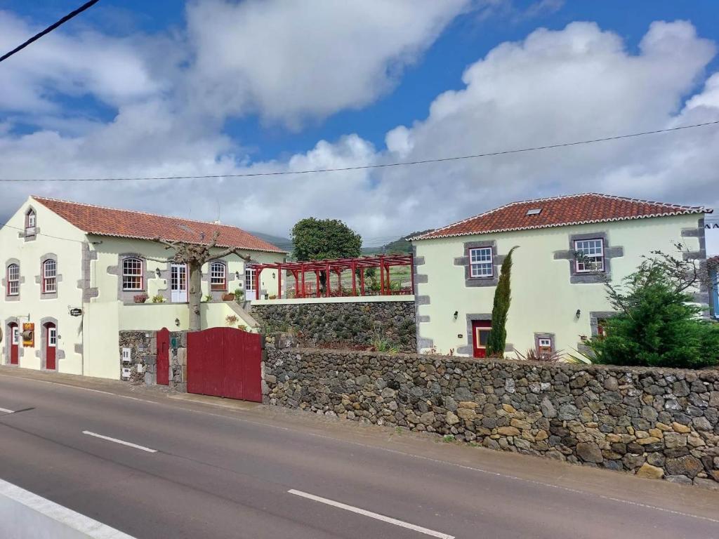 a house on the side of a road with a stone wall at Casa do Plátano in Cinco Ribeiras