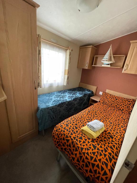 a small room with two beds and a window at 3 bedroom holiday home in South Hayling