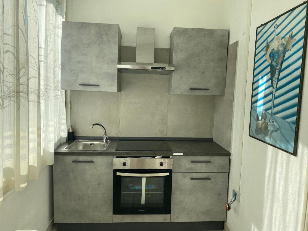 a small kitchen with a sink and a stove at Sea apartment, Gallipoli baia verde in Baia Verde