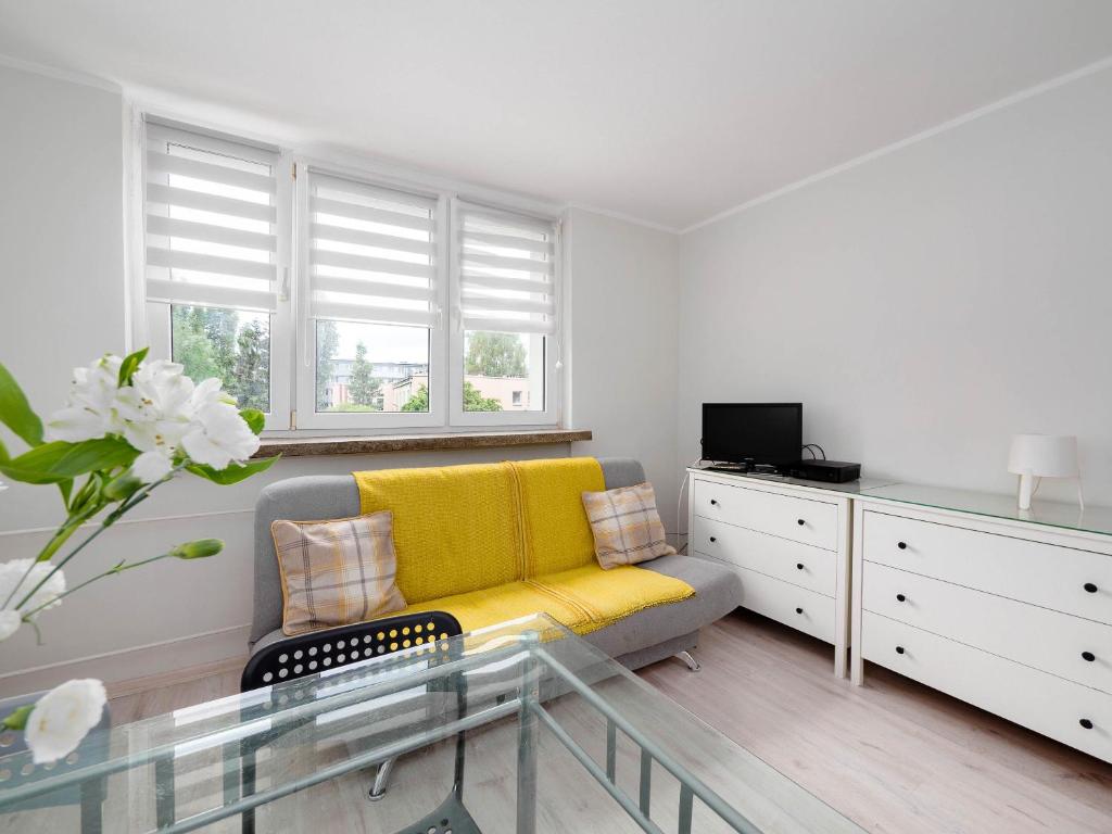 uma sala de estar com um sofá amarelo e uma mesa em Sweet Honey Mieszkanie w Płocku em Plock