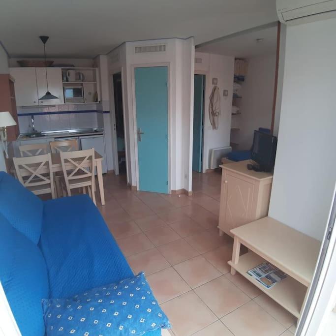 un salon avec un canapé bleu et une cuisine dans l'établissement Joli 2 pièces vue mer Parking Clim 50m plage, à Menton