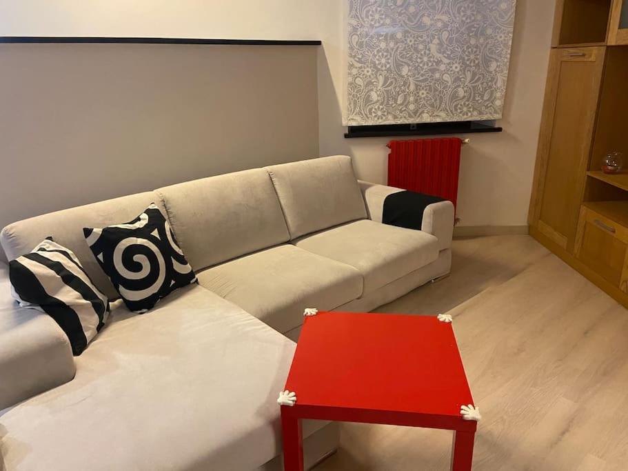 sala de estar con sofá blanco y mesa roja en A casa mia, en Acquapendente