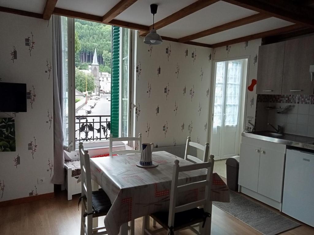 une cuisine avec une table et des chaises dans une pièce dans l'établissement Villa lutins Gentianes, à Le Mont-Dore