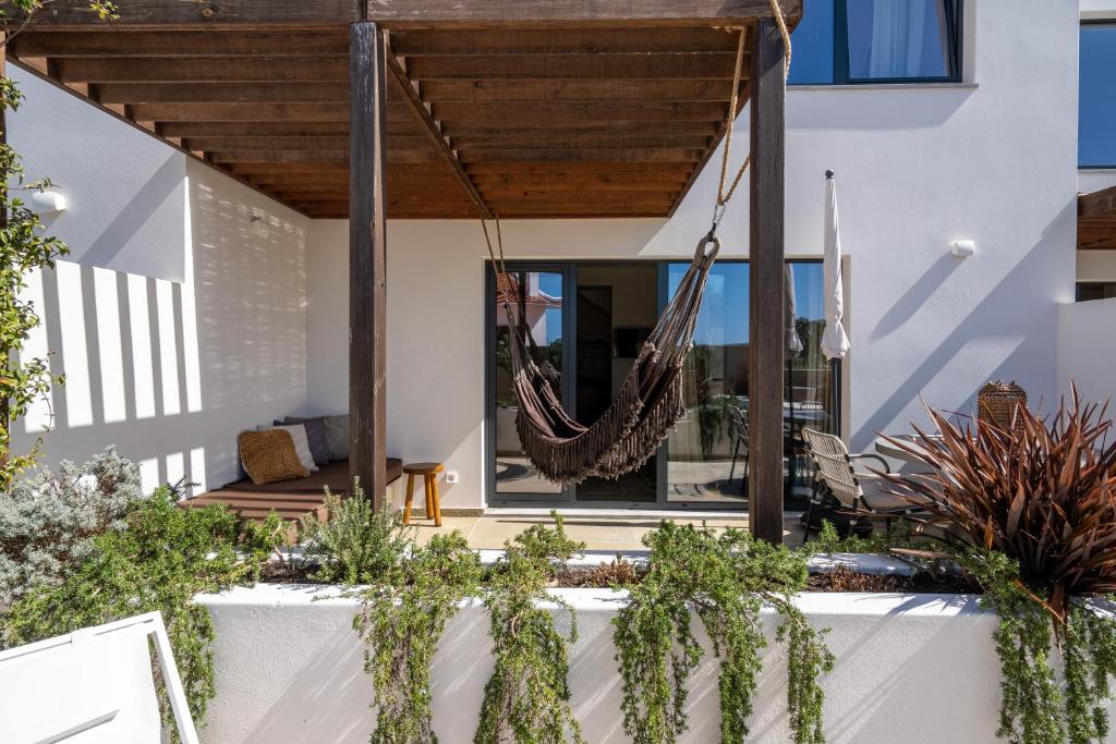 a patio with a hammock hanging from a house at Casa da Adraga in Colares