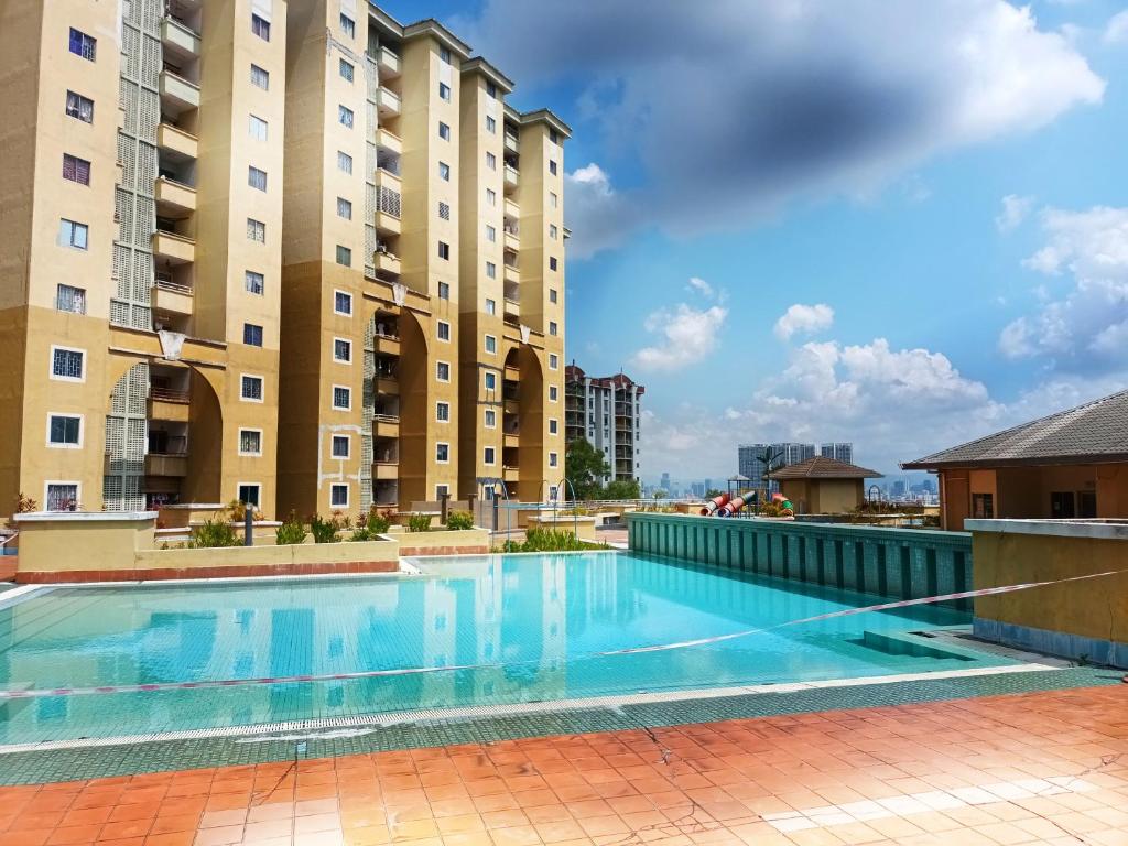 ein Schwimmbad vor zwei hohen Gebäuden in der Unterkunft 3 Bedrooms with Pool Hanan Residence Ketumbar Heights Condominium in Cheras