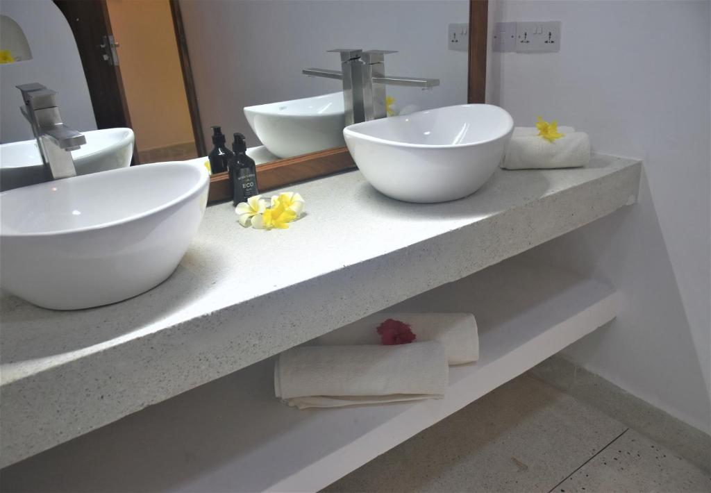 a bathroom with two sinks and towels on a counter at Blue Palm Zanzibar in Bwejuu