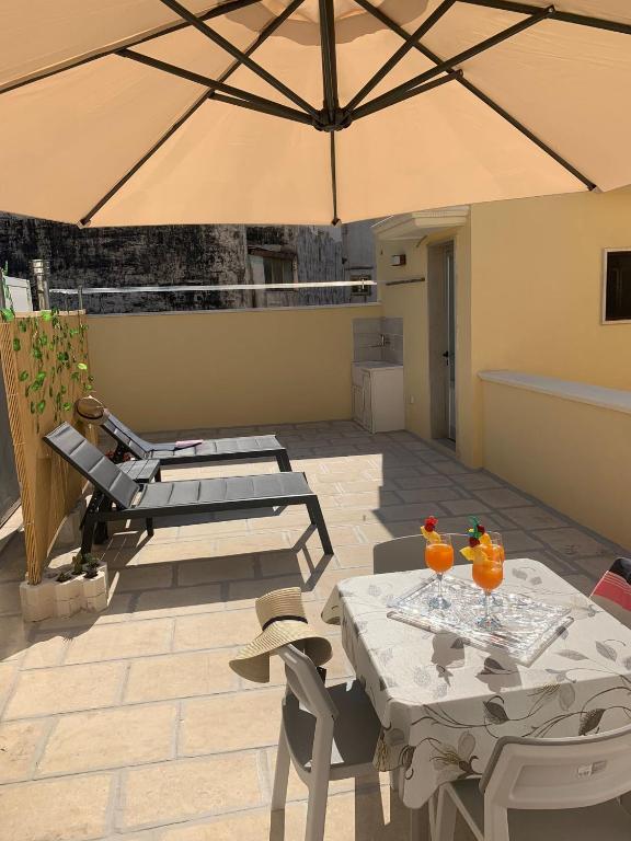 a patio with tables and a large umbrella at Romantica in Brindisi