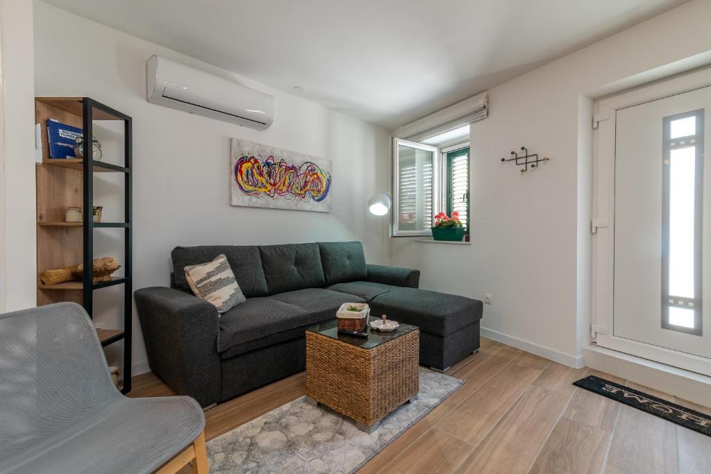 ein Wohnzimmer mit Sofa und Tisch in der Unterkunft Apartman Benzon Vranjic in Vranjic