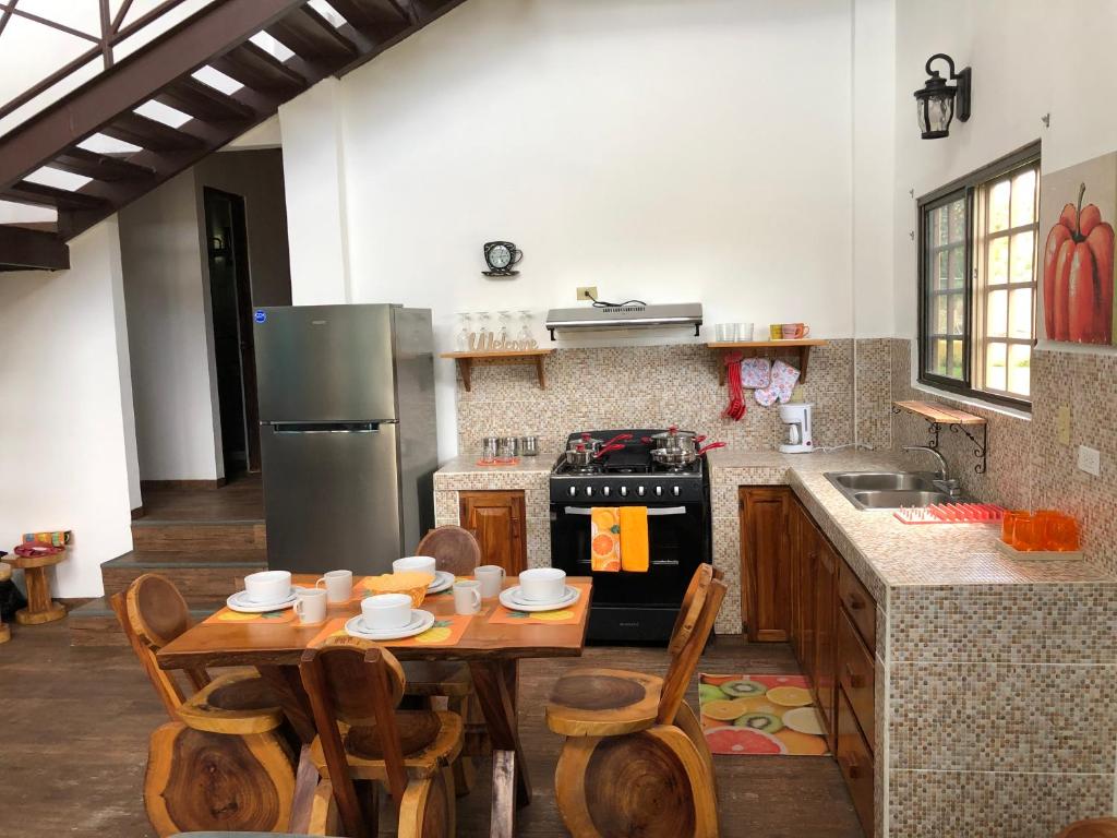 a kitchen with a wooden table and a refrigerator at Tu Cabaña en Boquete in Alto Boquete