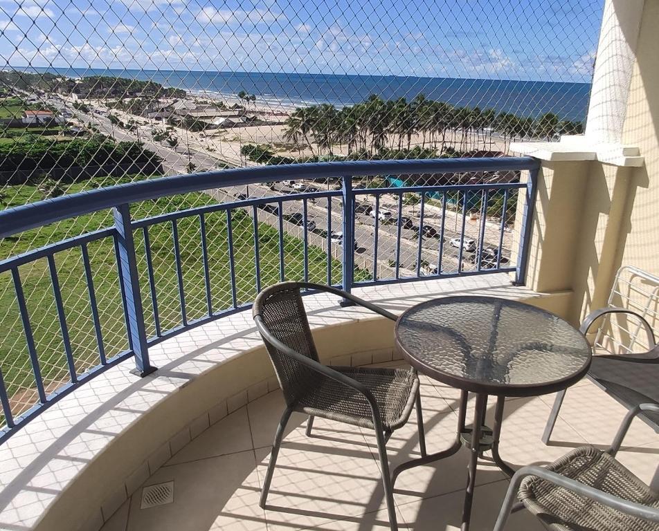 uma varanda com mesa e cadeiras e a praia em Apto vista p/ mar 7º andar em Fortaleza