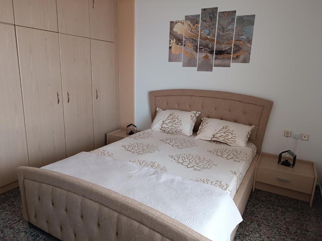 a bedroom with a bed with white sheets and pillows at Renas home in Anavyssos