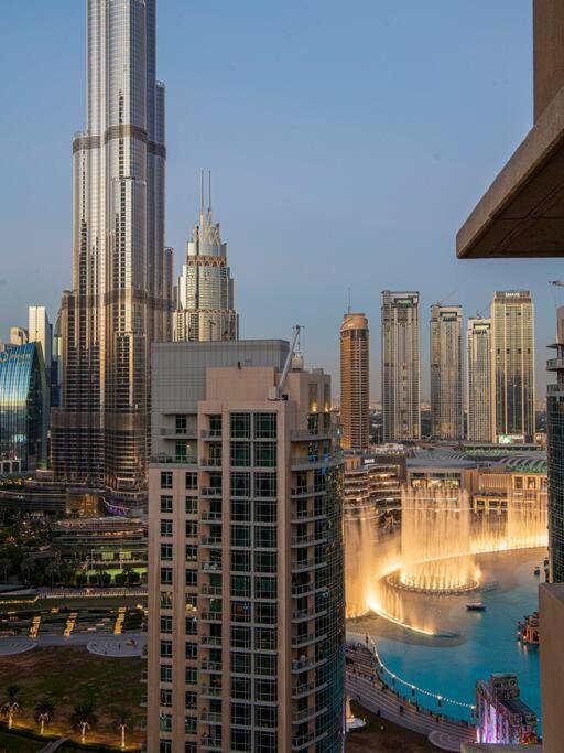 Hotel 2BR Burj View with Balcony, Pool, Gym & Walk to Dubai Mall, a view of a large city with a fountain at 2BR Burj View with Balcony, Pool, Gym & Walk to Dubai Mall in Dubai