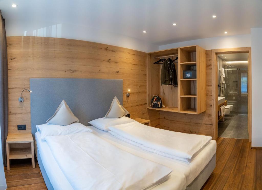 a bedroom with a large bed with white sheets at Apartments Montblanc Seceda in Ortisei