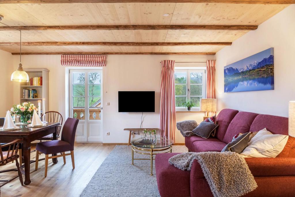 a living room with a purple couch and a table at Lisbeth in Rottenbuch