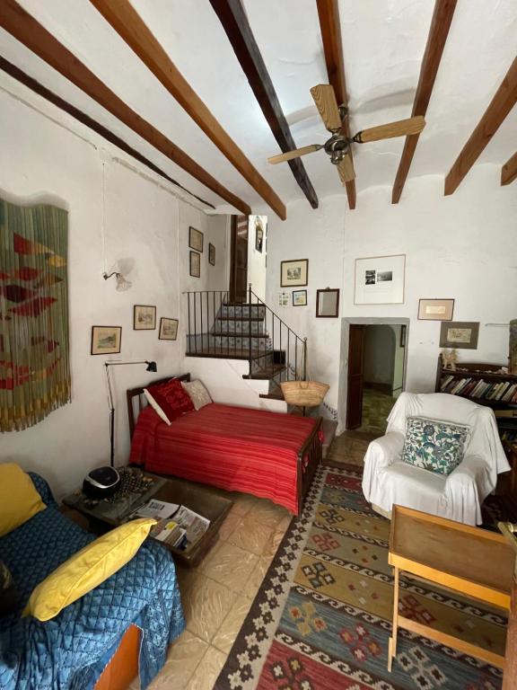 sala de estar con sofá y cama en Encantadora casita en el centro de Fornalutx, en Fornalutx