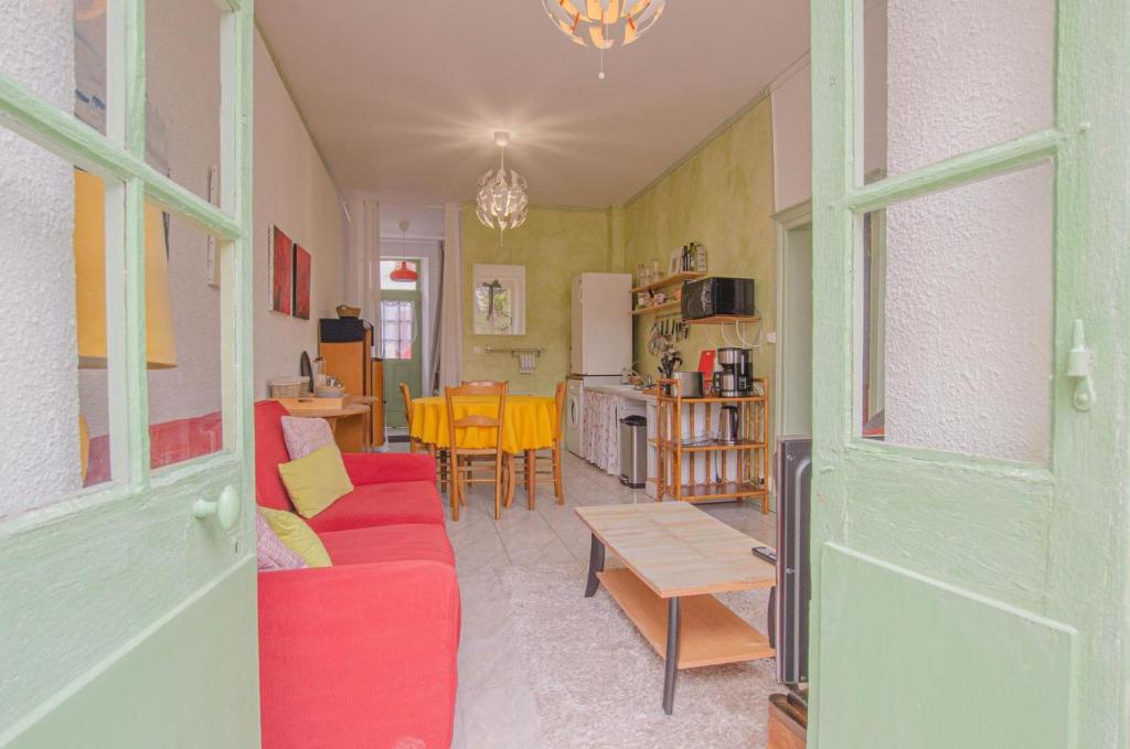a living room with a red couch and a table at Parenthese in Villenauxe-la-Grande