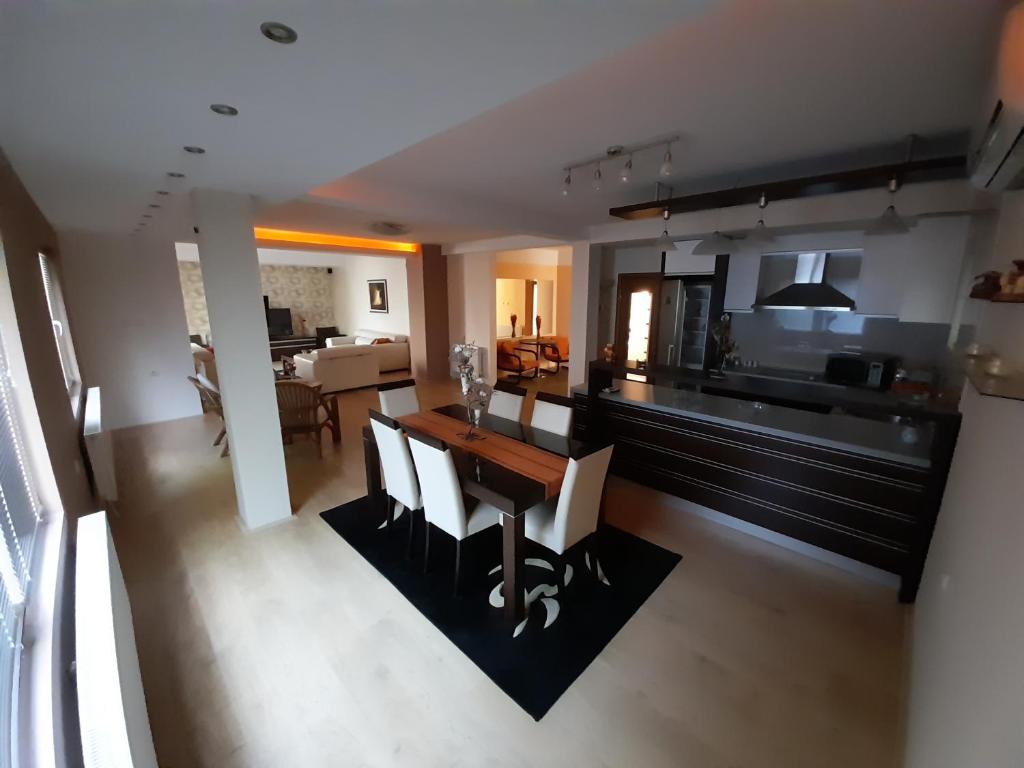 a kitchen and living room with a table and chairs at Omeros in Gevgelija