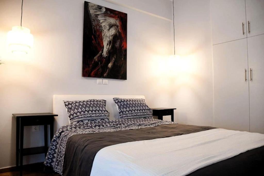 una camera da letto con un letto e un dipinto sul muro di Διαμέρισμα vasiliki στο κέντρο της Αθήνας ad Atene