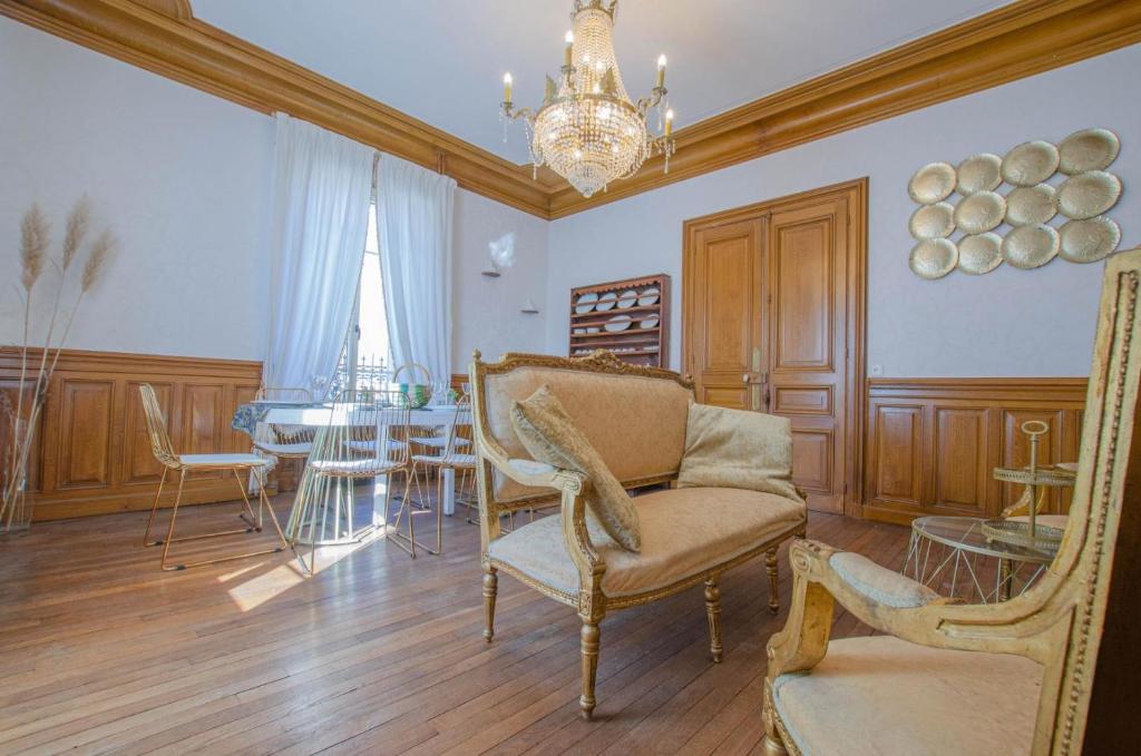 布里維安德斯的住宿－L'instant champenois，客厅配有桌椅和吊灯。