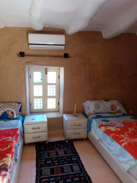 塔魯丹特的住宿－Douar amazza，一间卧室设有两张床和窗户。