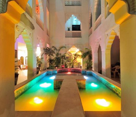 a large swimming pool in a building with lights in it at Jyoti Mahal - A Heritage Hotel - New Delhi in New Delhi