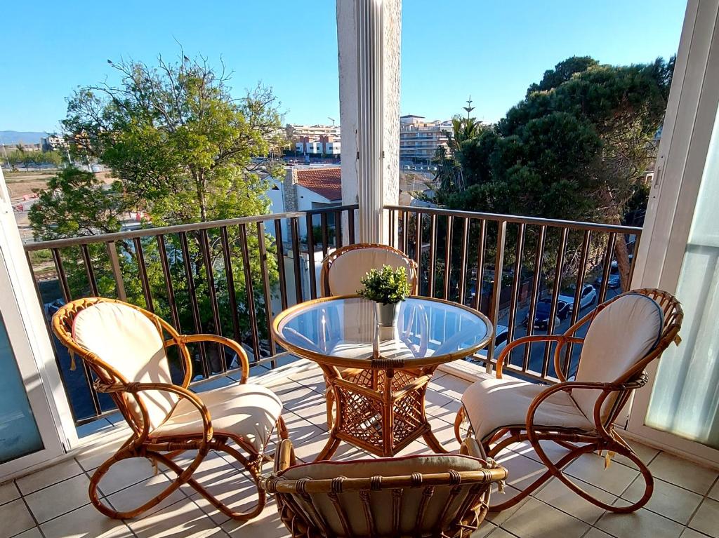 a patio with a glass table and chairs on a balcony at Sol Marina Apartment in Salou
