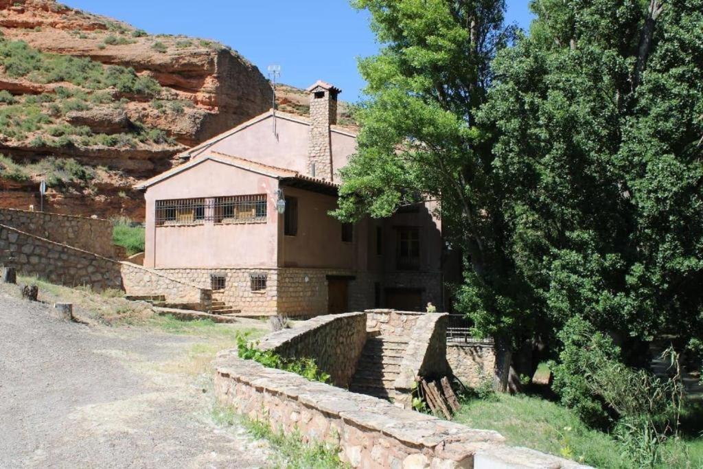 uma casa ao lado de uma montanha em EL MOLINO De Villel em Villel