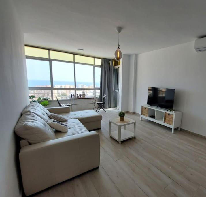 - un salon avec un canapé et une télévision dans l'établissement Macarena´s Home *Sea view*-Saltillo Alto, à Torremolinos