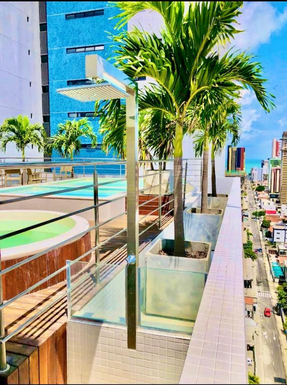 a building with palm trees on the side of a street at PHGFlats Manaira apart hotel in João Pessoa