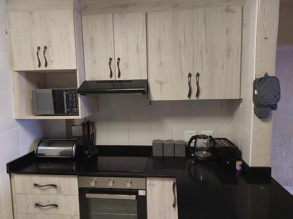 eine Küche mit Holzschränken und einer schwarzen Arbeitsplatte in der Unterkunft 1 La Corona St Micheals in Margate
