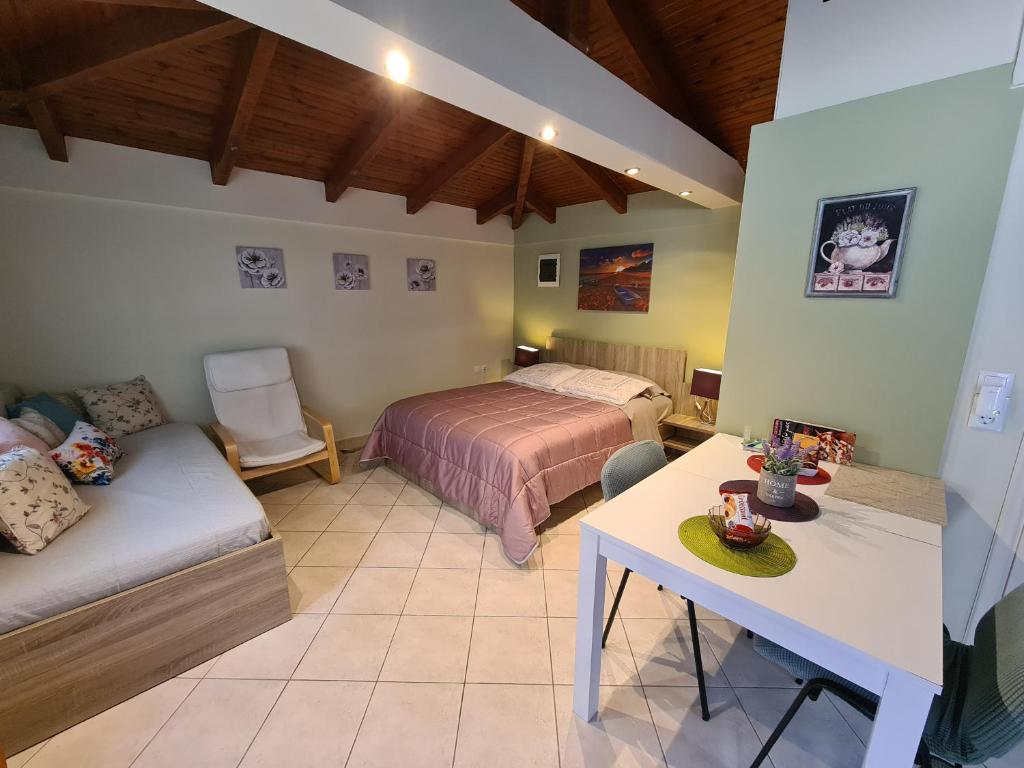 1 dormitorio con cama, sofá y mesa en Semelia's Guest house en Spáta