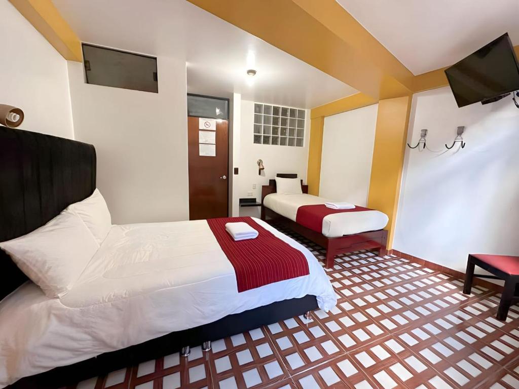 a hotel room with a bed and a tv at MACHUPICCHU BOUTIQUE in Machu Picchu