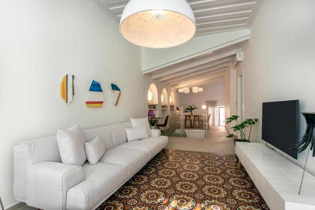 Una sala de estar con un sofá blanco y un televisor de pantalla plana. en On Luxury Chania, en La Canea