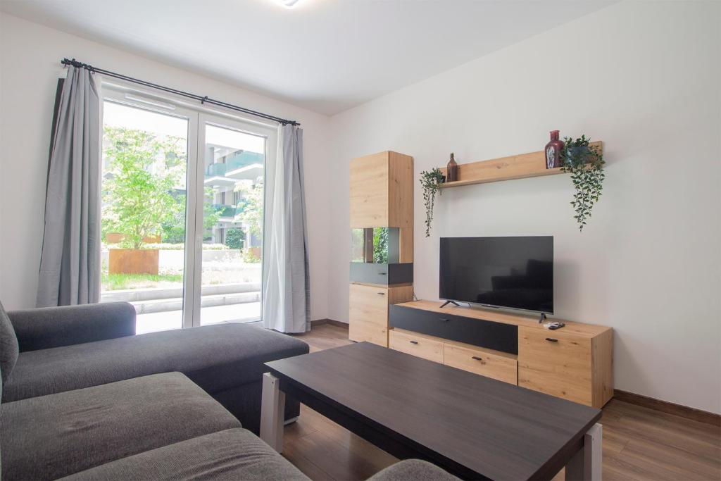 un soggiorno con divano e TV di Corvin Modern Two Bedroom Apartment FREE PARKING a Budapest