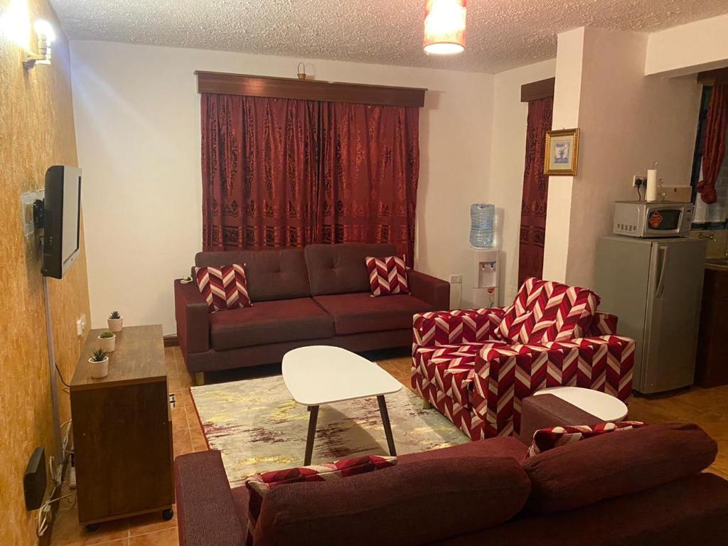 a living room with a couch and two chairs at Kithinji Apartments in Nairobi