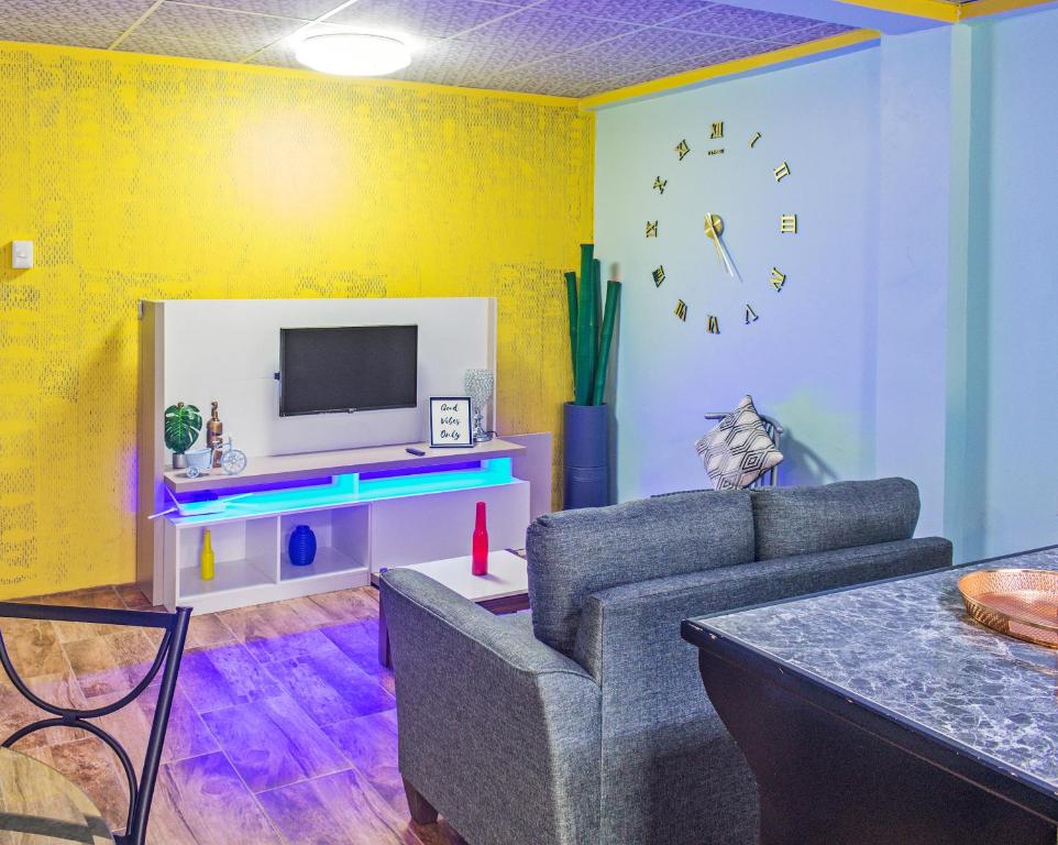 een woonkamer met een bank en een tv bij Villa De Cruz - Groovy Suite in Scarborough