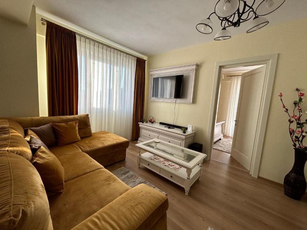 a living room with a couch and a tv at Apartament Rose in Gura Humorului