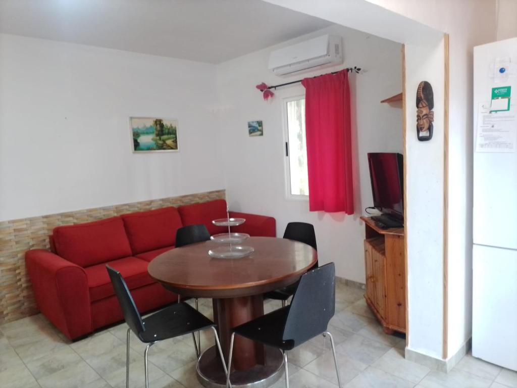 een woonkamer met een rode bank en een tafel bij Eureka 133 in Costa Del Silencio