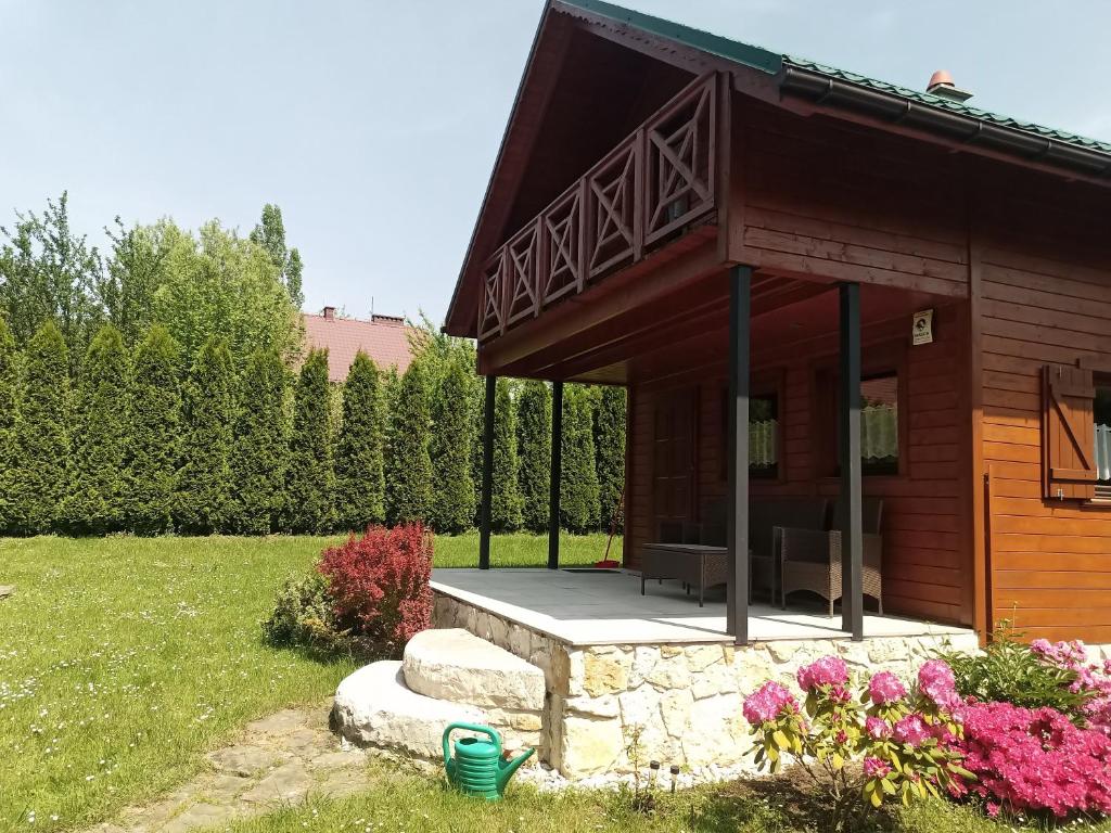 Cabaña de madera pequeña con porche en un patio en Domek całoroczny, en Bielsko-Biala