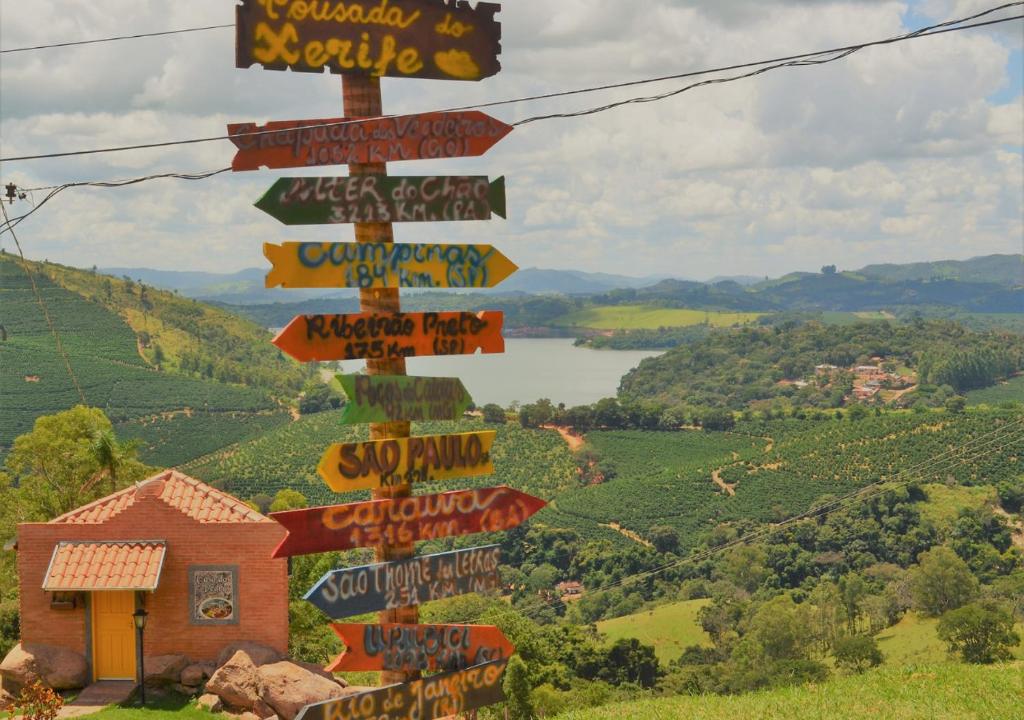 ein Straßenschild mit vielen Schildern auf einem Hügel in der Unterkunft Pousada do Xerife in Caconde