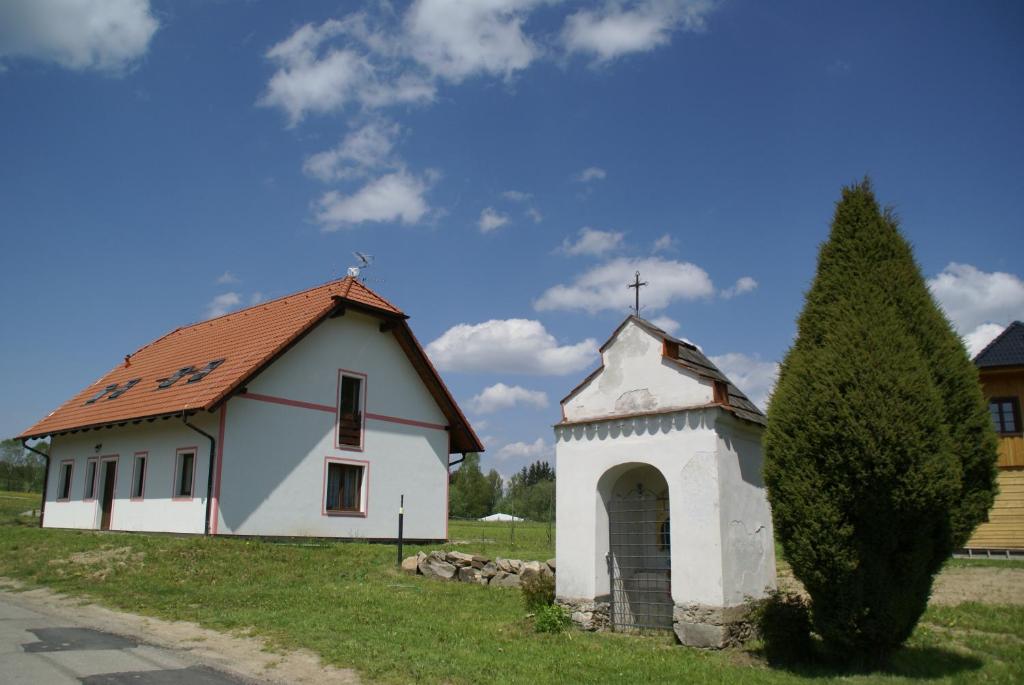 Une petite église blanche avec une croix en haut dans l'établissement Apartmány u Olšinské kapličky, à Horní Planá