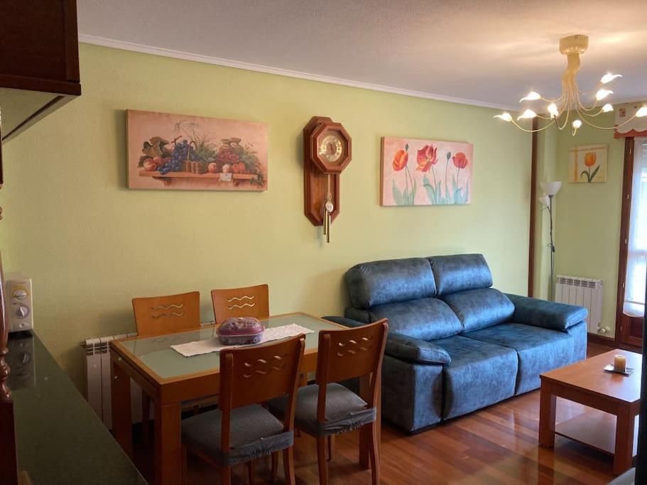 ein Wohnzimmer mit einem blauen Sofa und einem Tisch in der Unterkunft Bella Vista in Ramales de la Victoria