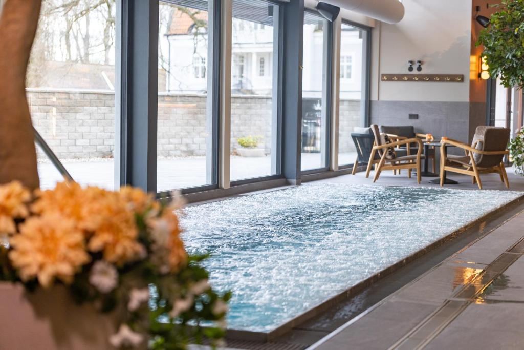 uma piscina no meio de uma sala com janelas em Starby Spa, Hotell & Konferens em Vadstena