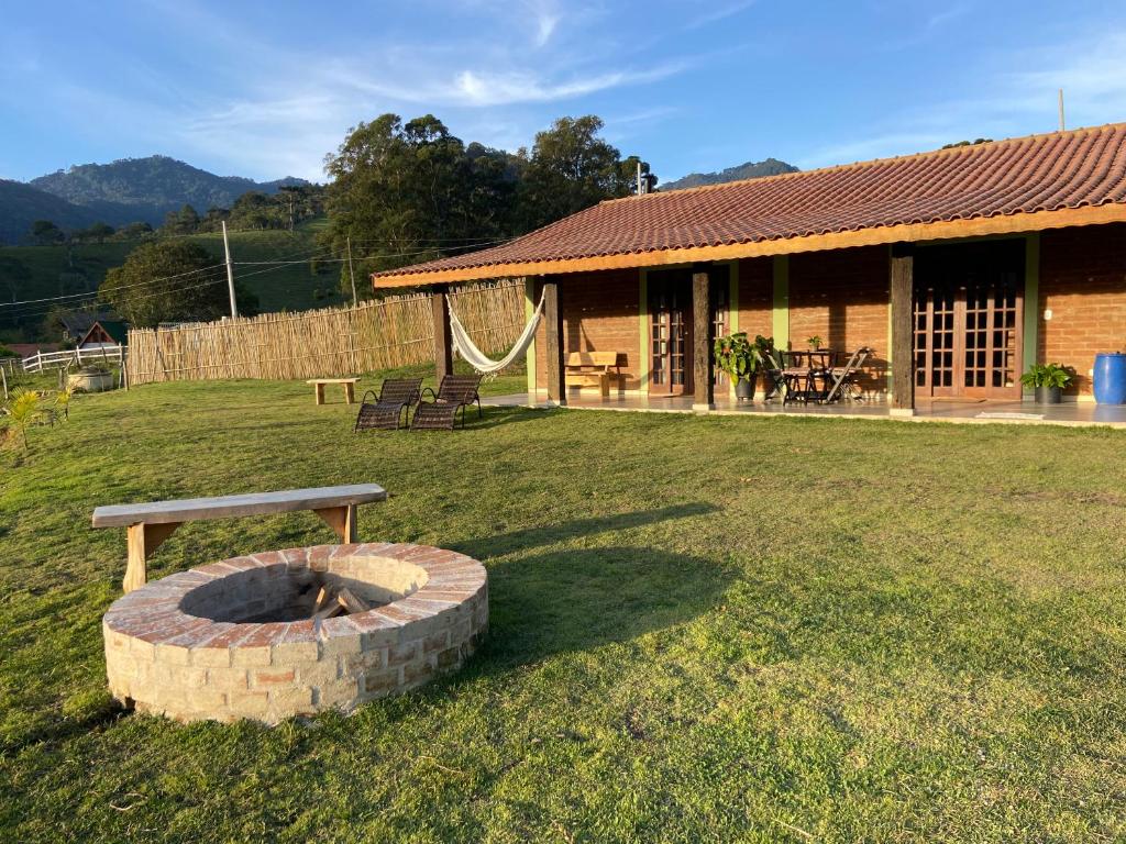a house with a fire pit in the yard at Villagio Angatu in Santo Antônio do Pinhal