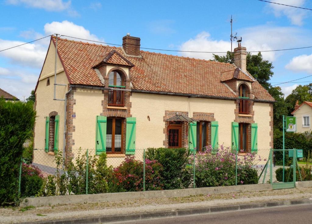 ein altes Haus mit grünen Rollläden auf einer Straße in der Unterkunft Le beau lieu in Maizières-la-Grande-Paroisse